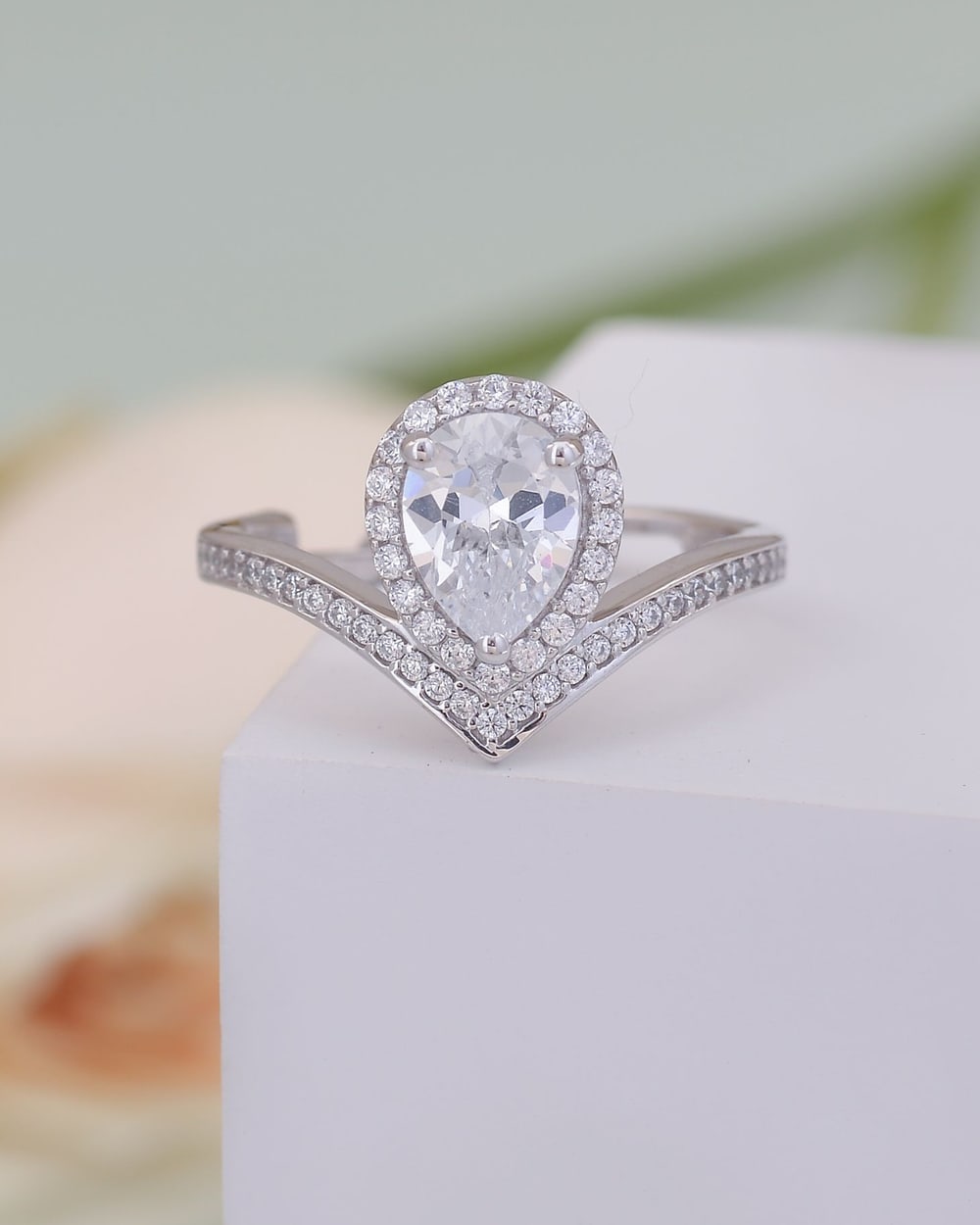 Pear-shaped diamond halo ring with a pavé chevron band