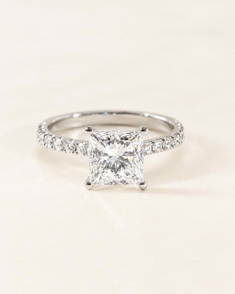 Princess-cut diamond solitaire ring with a pavé white gold band